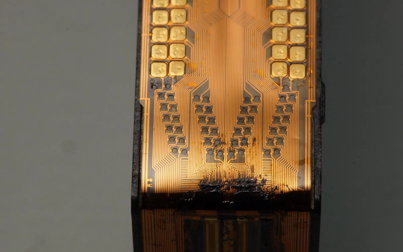 Close-up of a used inkjet cartridge with dried ink around its electrical contacts