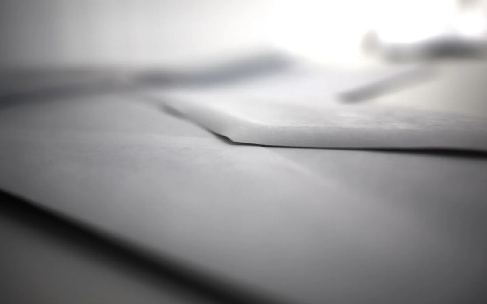 Primer plano de la solapa doblada de un sobre blanco sobre un escritorio