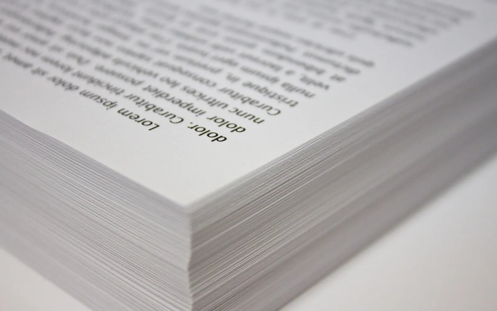 Close-up of the corner of a thick stack of printed copy paper
